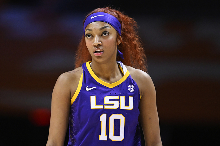 A female basketball player in an LSU jersey with the number 10 focused during a game