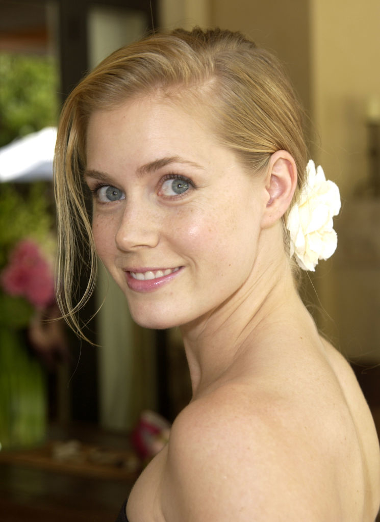 Amy with hair up and white flower accessory, looking over her shoulder