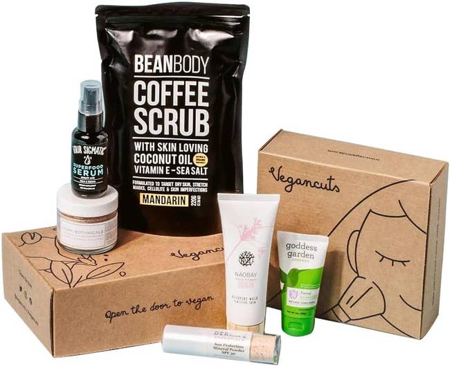 Assorted vegan beauty products including a coffee scrub, serum, lotion, and lip balm displayed with packaging