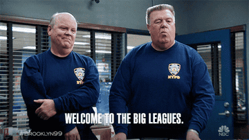 Hitchcock and Scully from Brooklyn Nine-Nine wear NYPD uniforms, doing a fist bump. Text: "Welcome to the big leagues. #Brooklyn99"