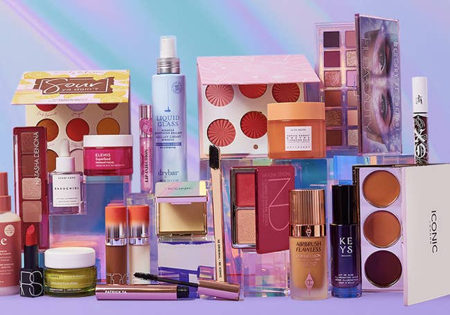 Assorted makeup and skincare products from various brands displayed against a gradient background