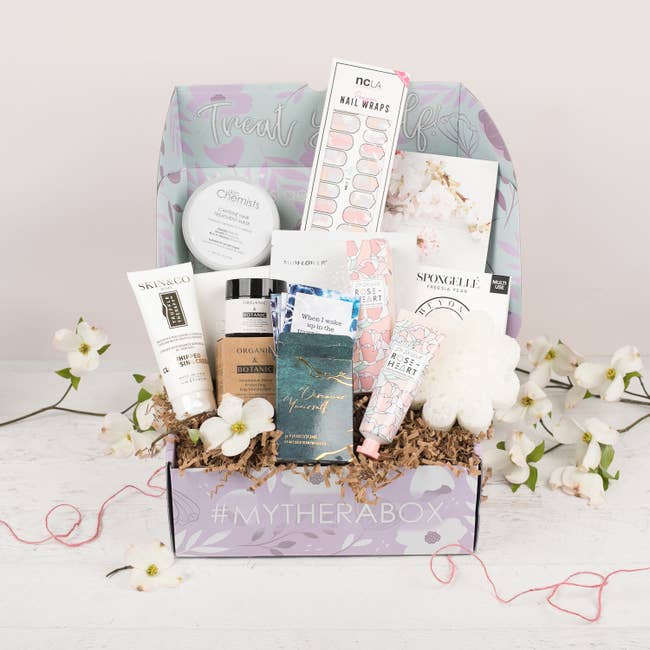 Assortment of self-care products in a subscription box with flowers