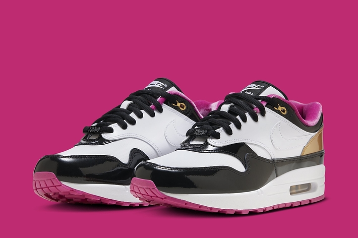 A pair of stylish sneakers with patent black and white design, gold accents, and pink interior