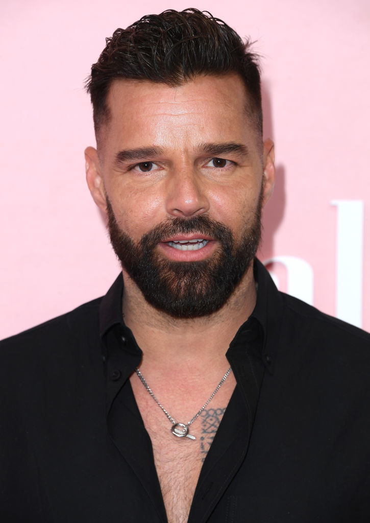 Ricky Martin posing for a photo with a black shirt and a necklace
