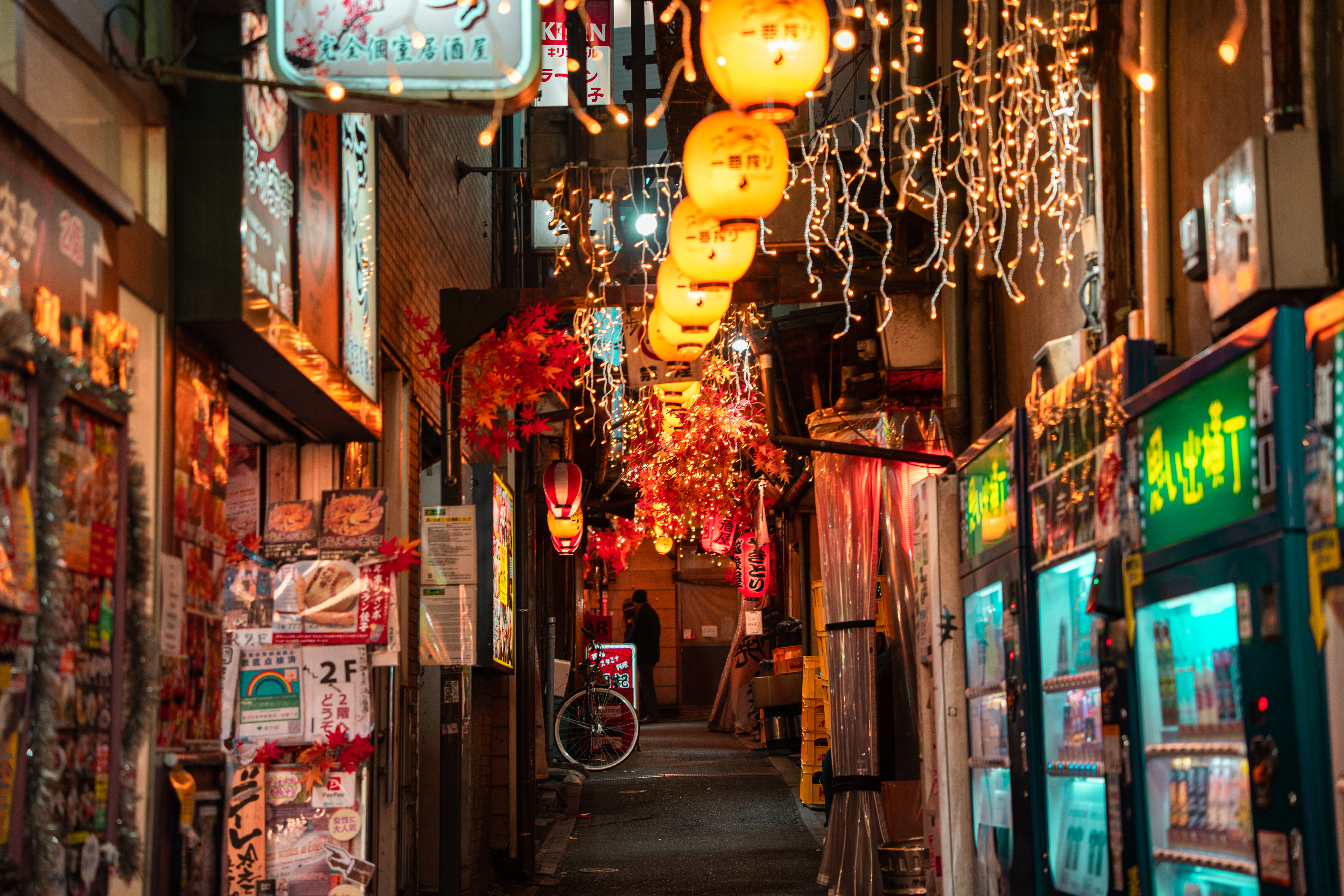 Lantern-lit alley with shops and a bicycle, capturing the ambiance of a travel destination
