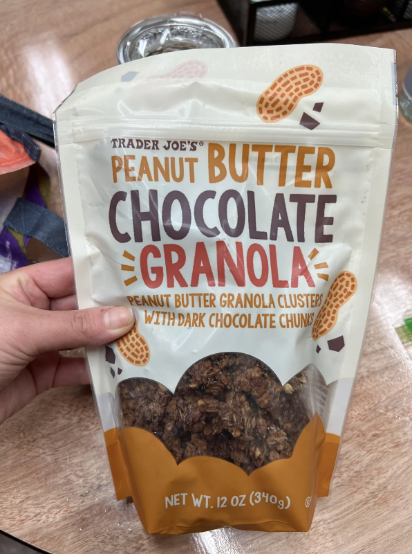 Package of Trader Joe&#x27;s Peanut Butter Chocolate Granola Clusters with dark chocolate chunks, held in a hand