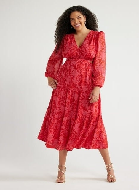 model in a red patterned dress with sheer sleeves and strappy sandals