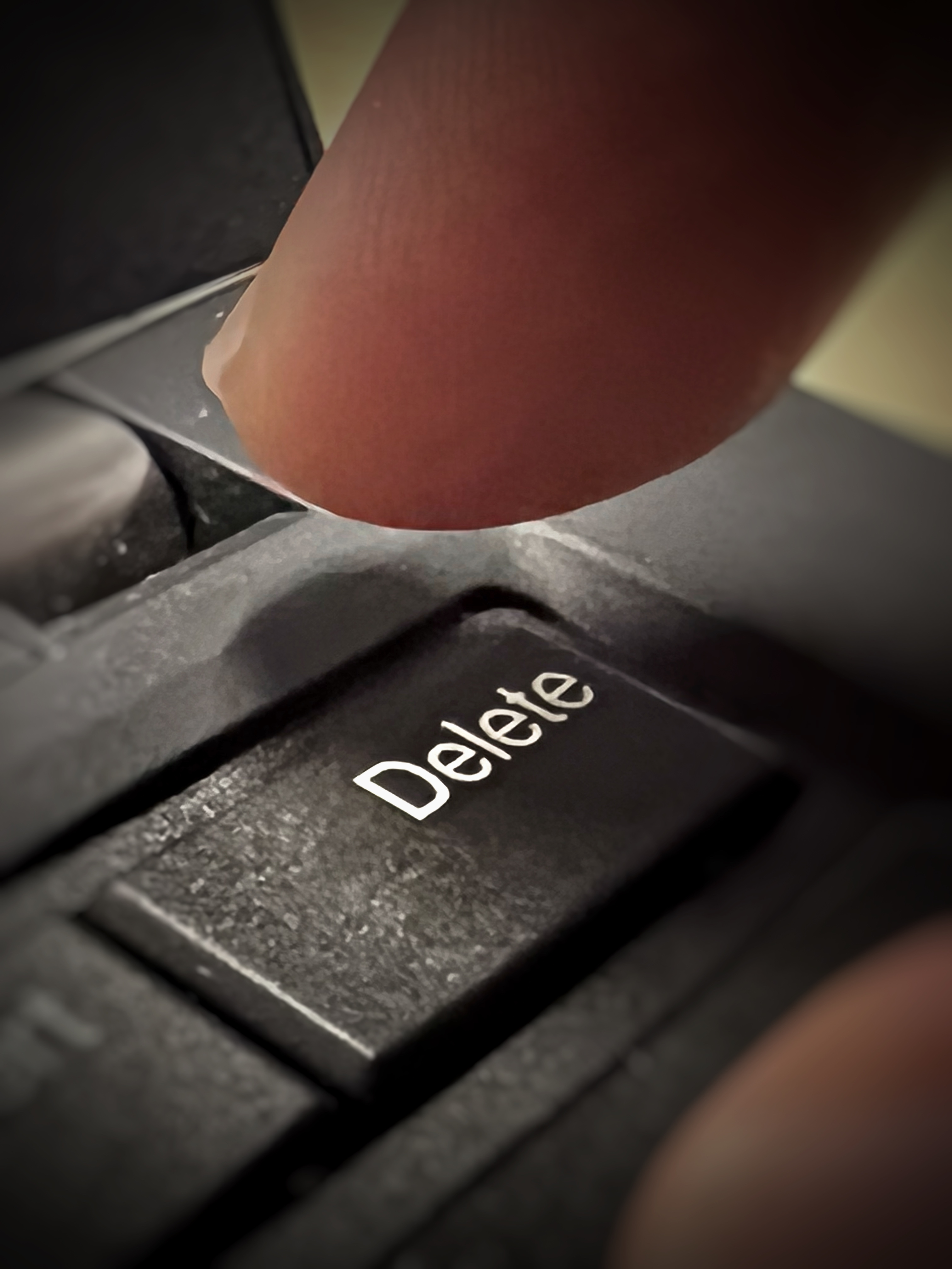 Close-up of a finger above a keyboard&#x27;s delete key