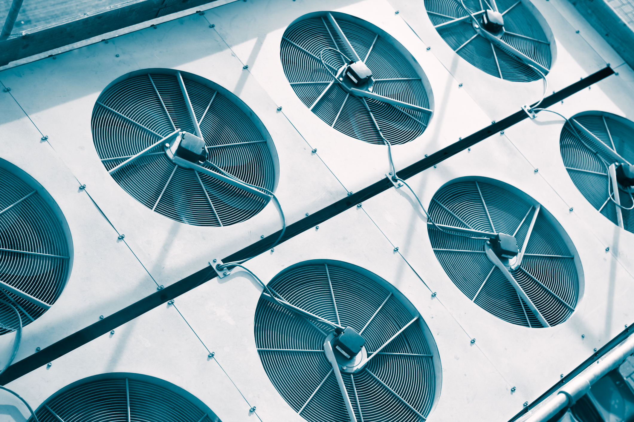 Array of industrial fans on a building&#x27;s exterior, viewed from above