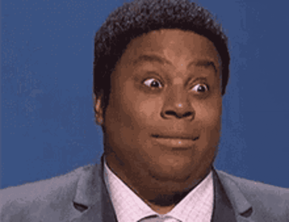 Person making a surprised facial expression in a suit and tie