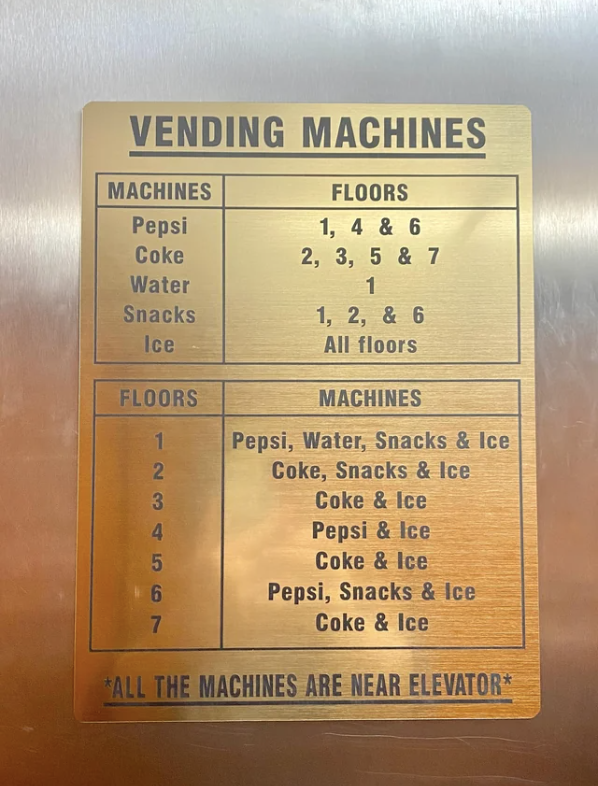 Vending machine directory sign with machine and floor listings for Pepsi, Coke, water, snacks, and ice