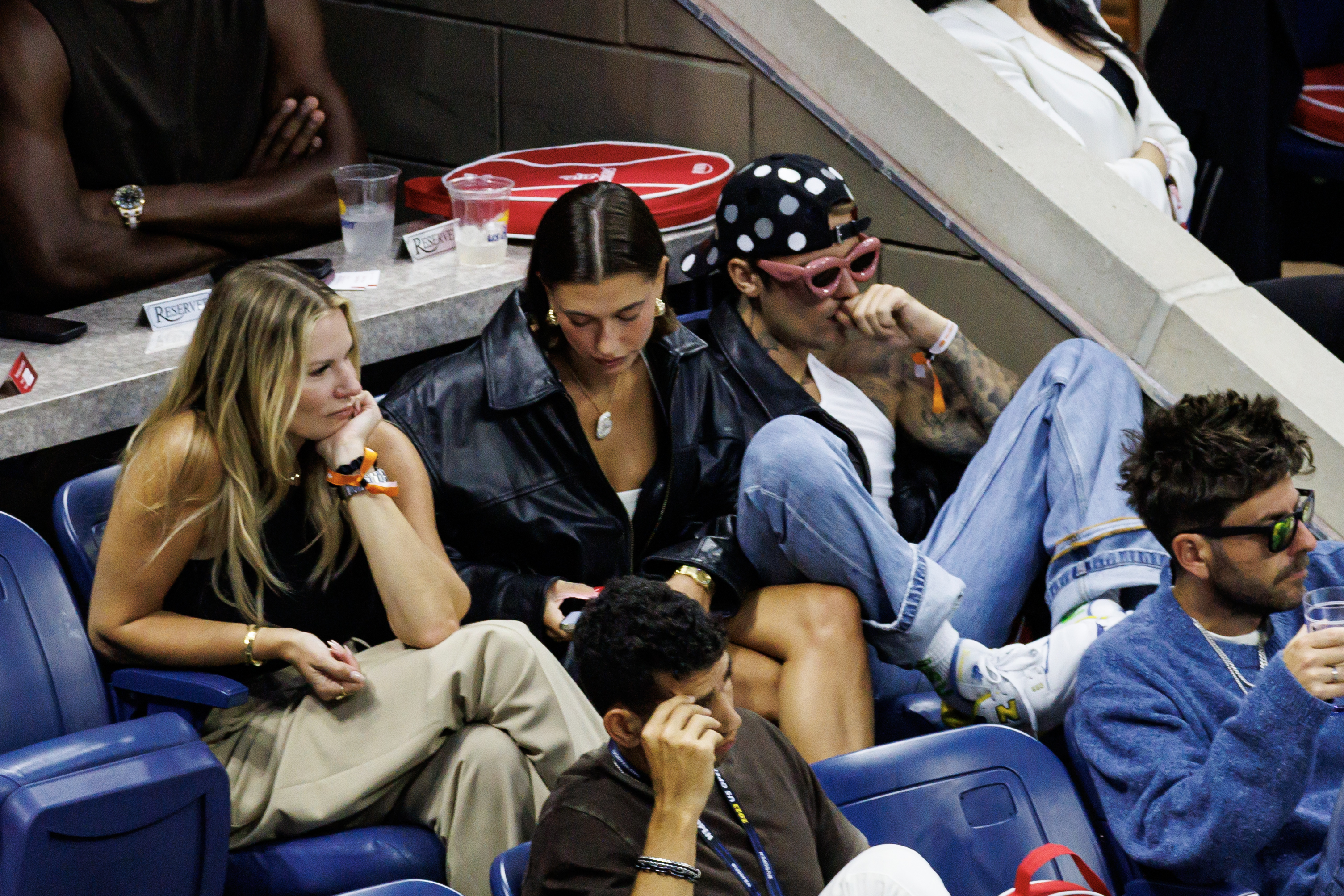 hailey and justin sitting with friends at a sports event