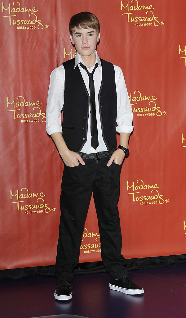 Wax figure resembling Justin Bieber in a vest, shirt, and pants at Madame Tussauds