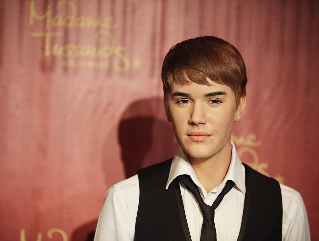 Wax figure of Justin Bieber wearing a vest, shirt, and tie
