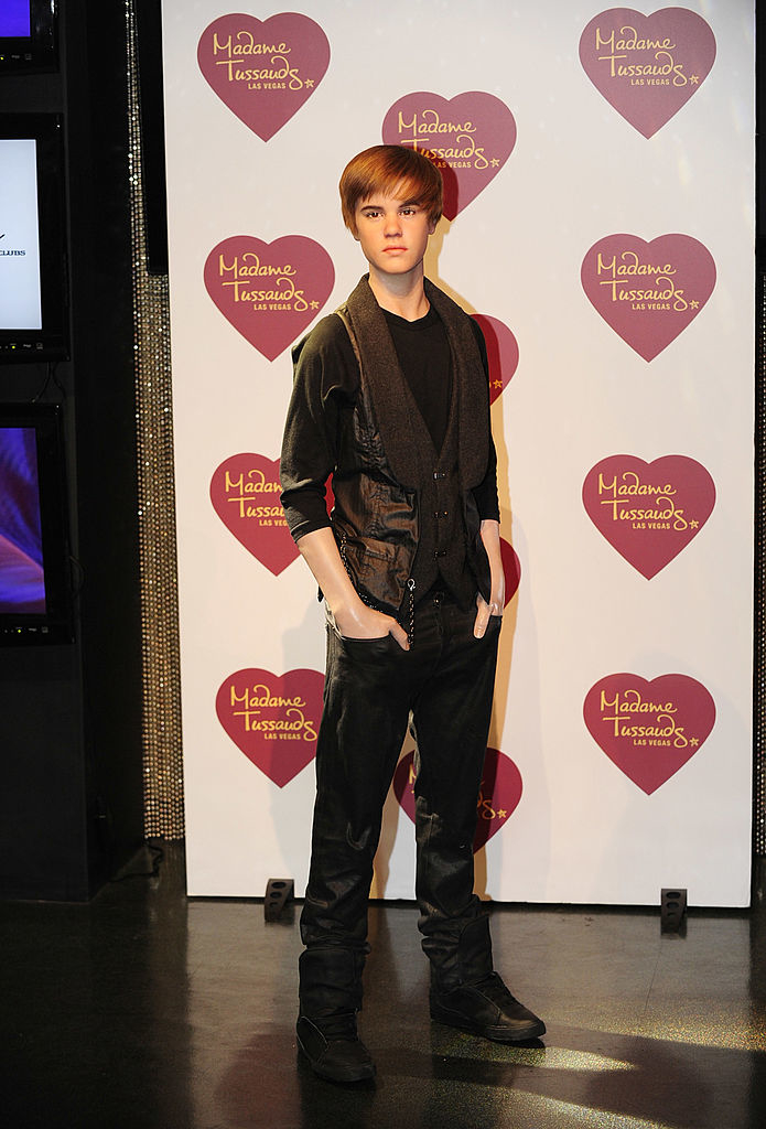 Wax figure of Justin Bieber at Madame Tussauds, wearing an outfit and boots, standing with hands in pockets