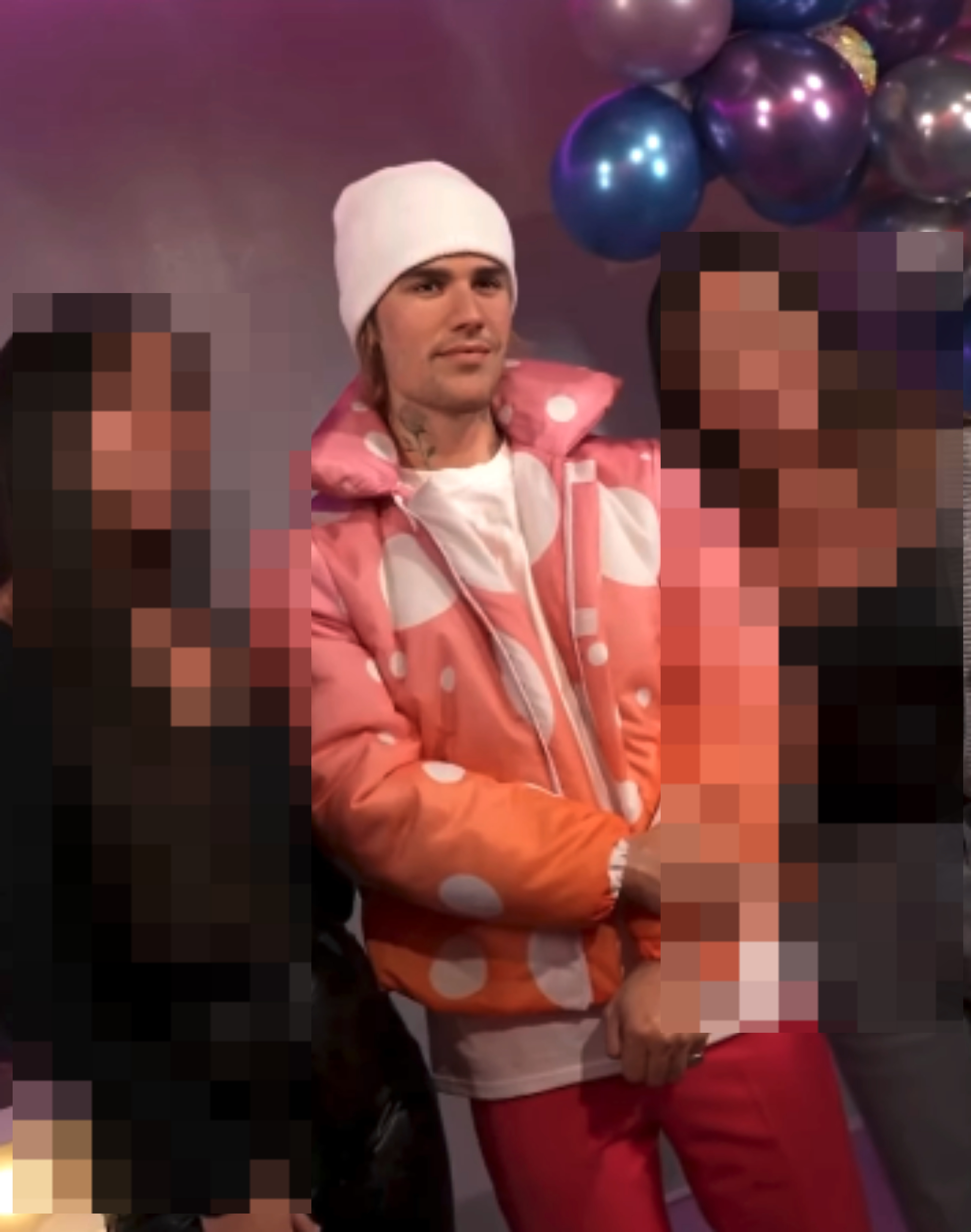 Justin Bieber with two fans, wearing a polka dot jacket and beanie