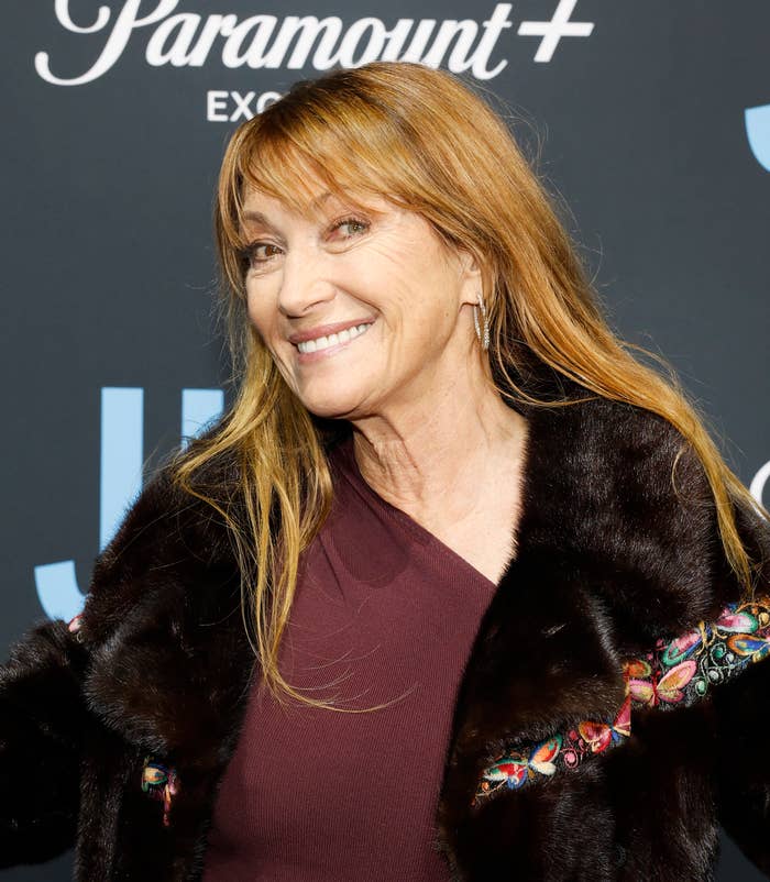 Jane Seymour smiles on the red carpet, wearing a v-neck top and beaded fur coat