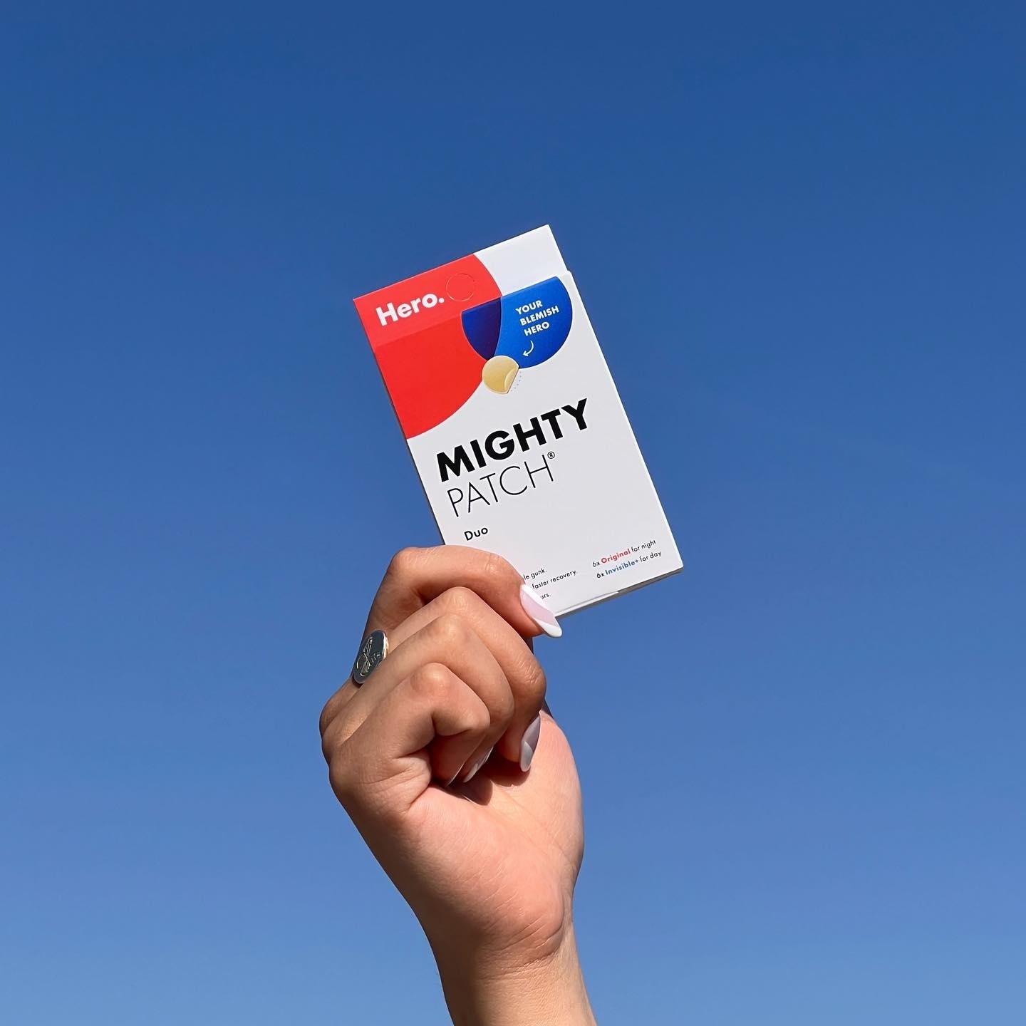 Model holding the patches against a clear sky