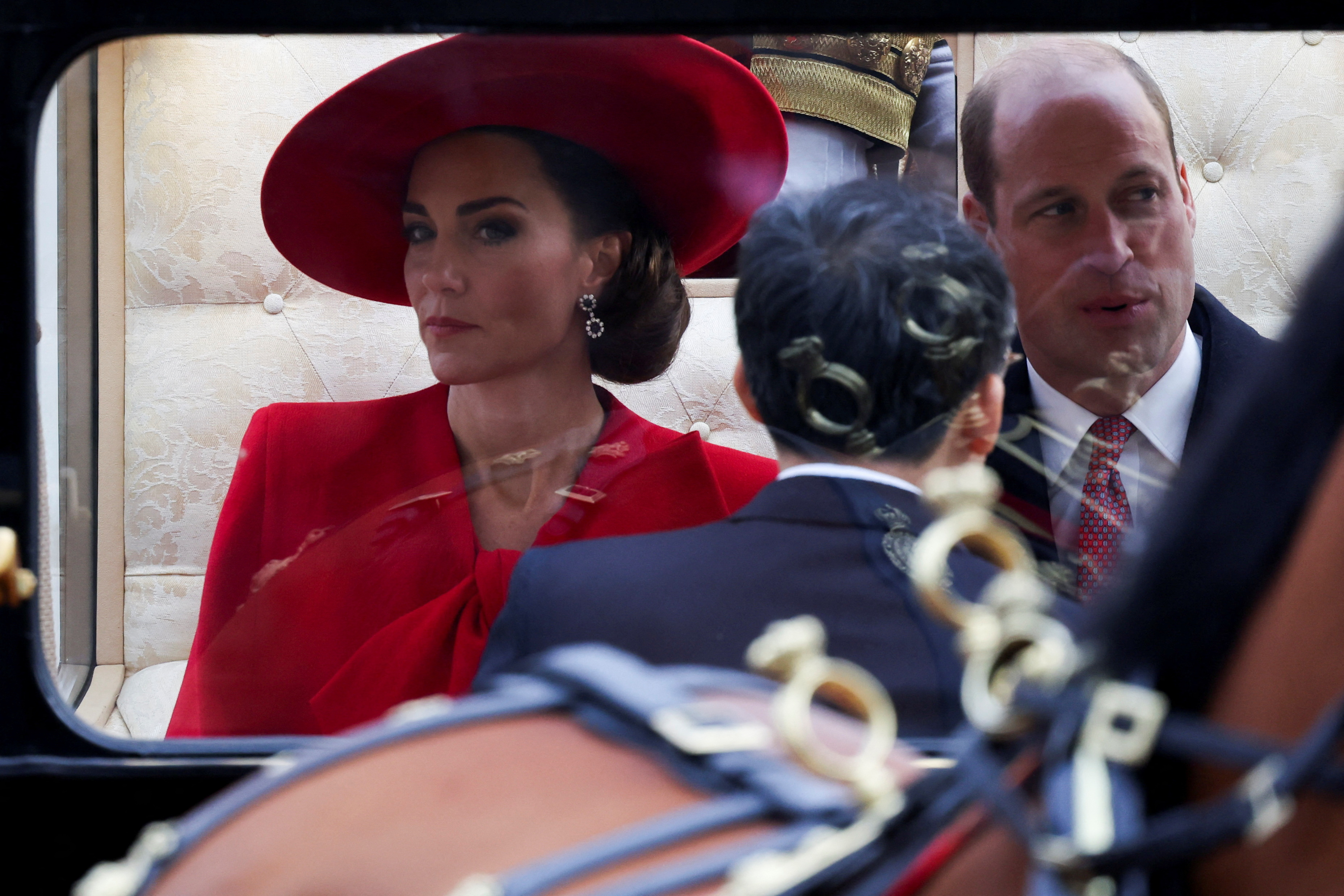 Prince William and Kate Middleton in a carriage, Kate in a large hat and matching outfit, Prince William in a suit and tie