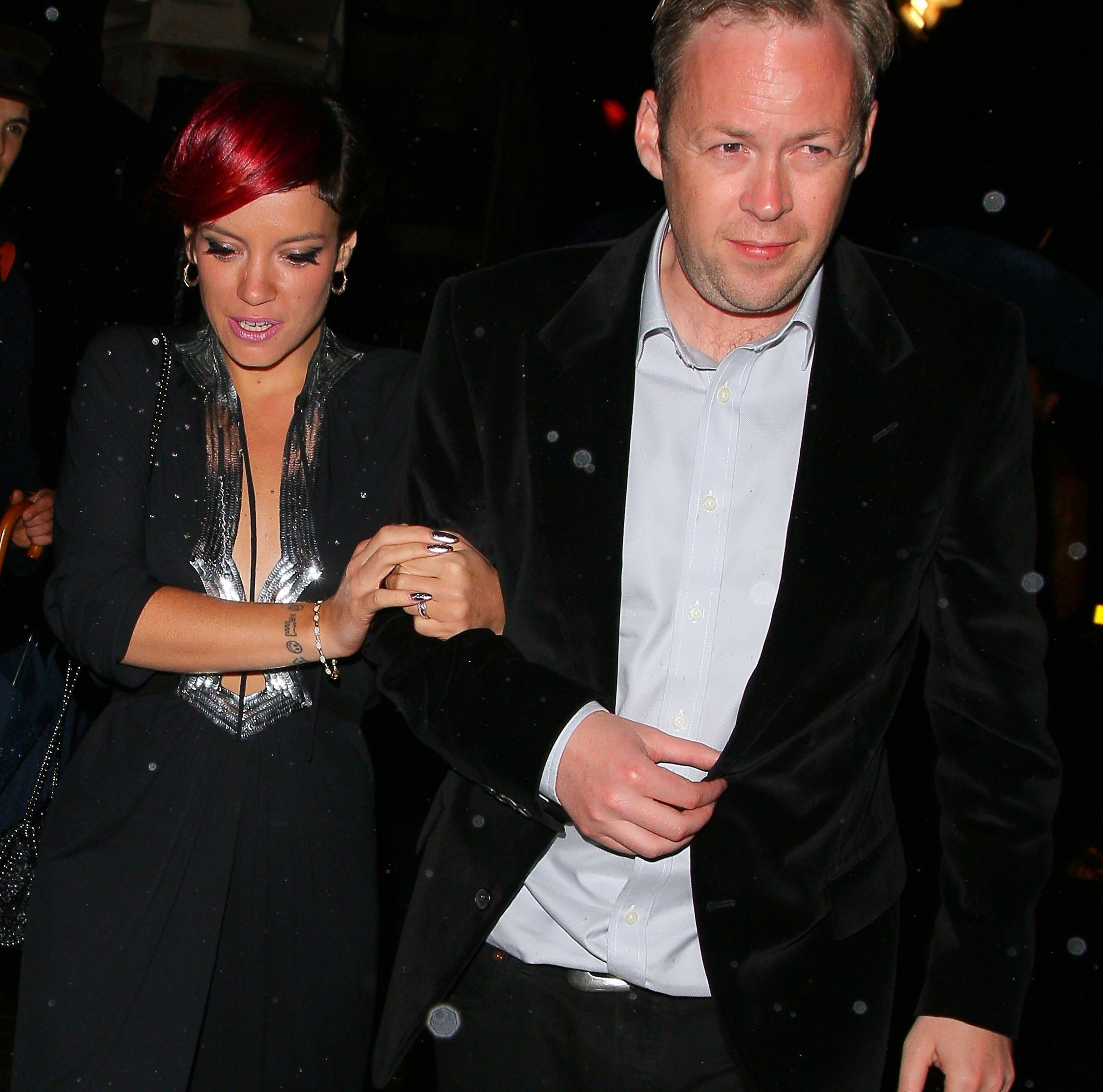 Lily Allen and Sam Cooper walk together, Allen in a black evening dress and Cooper in a suit