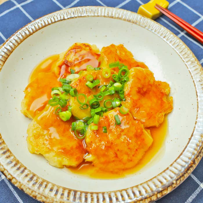 皿に盛られた豆腐にねぎがトッピングされています。