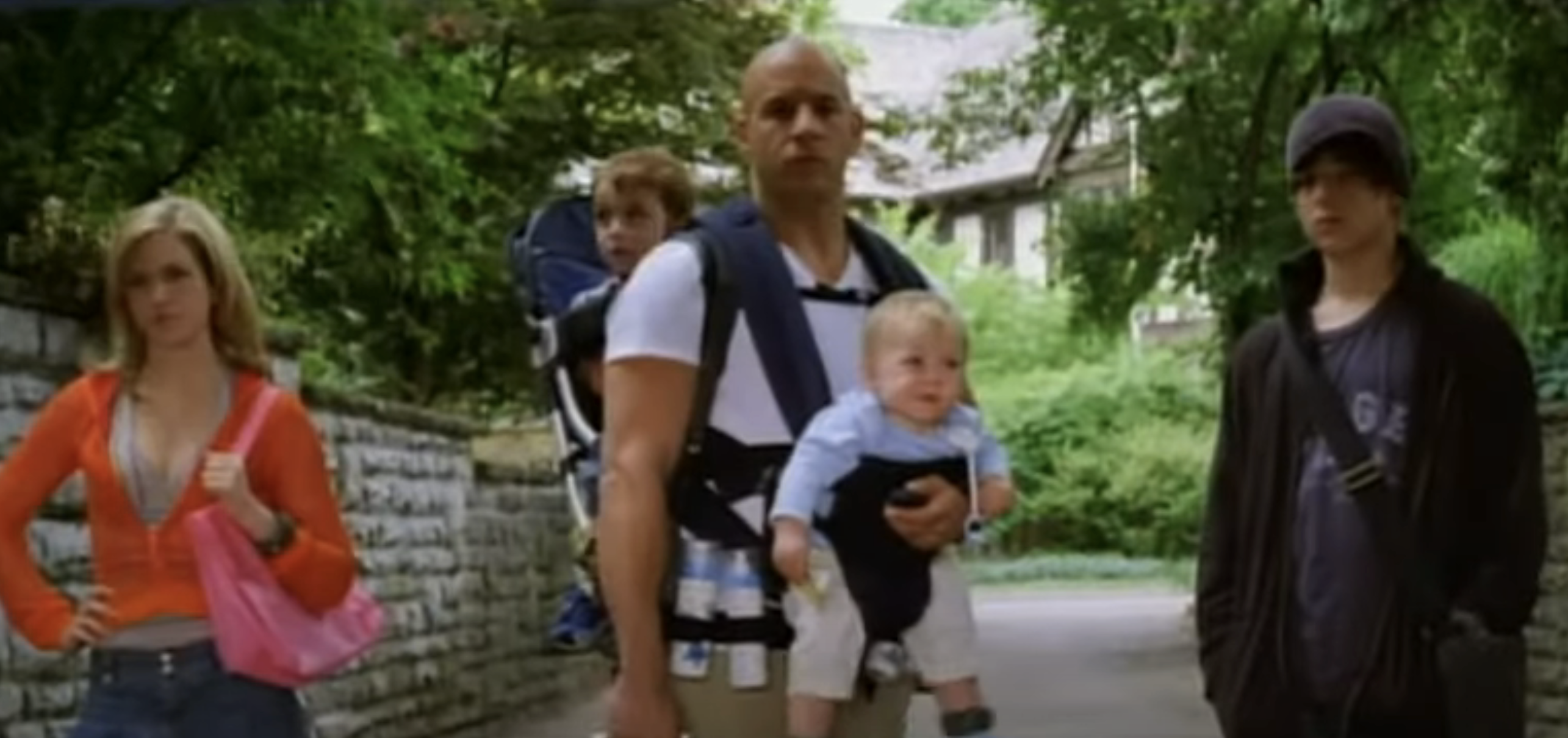 Vin Diesel with child in carrier and co-stars in a scene from &quot;The Pacifier.&quot;