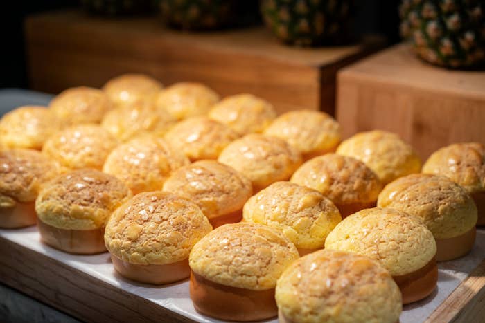 Freshly baked pineapple buns arranged neatly on a counter
