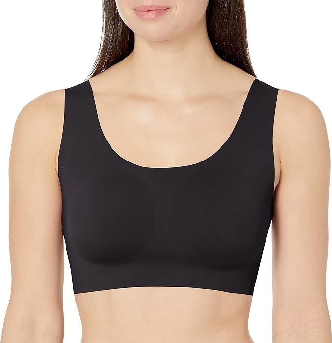 Woman in a plain scoop-neck sports bra, close-up focused on upper body and garment