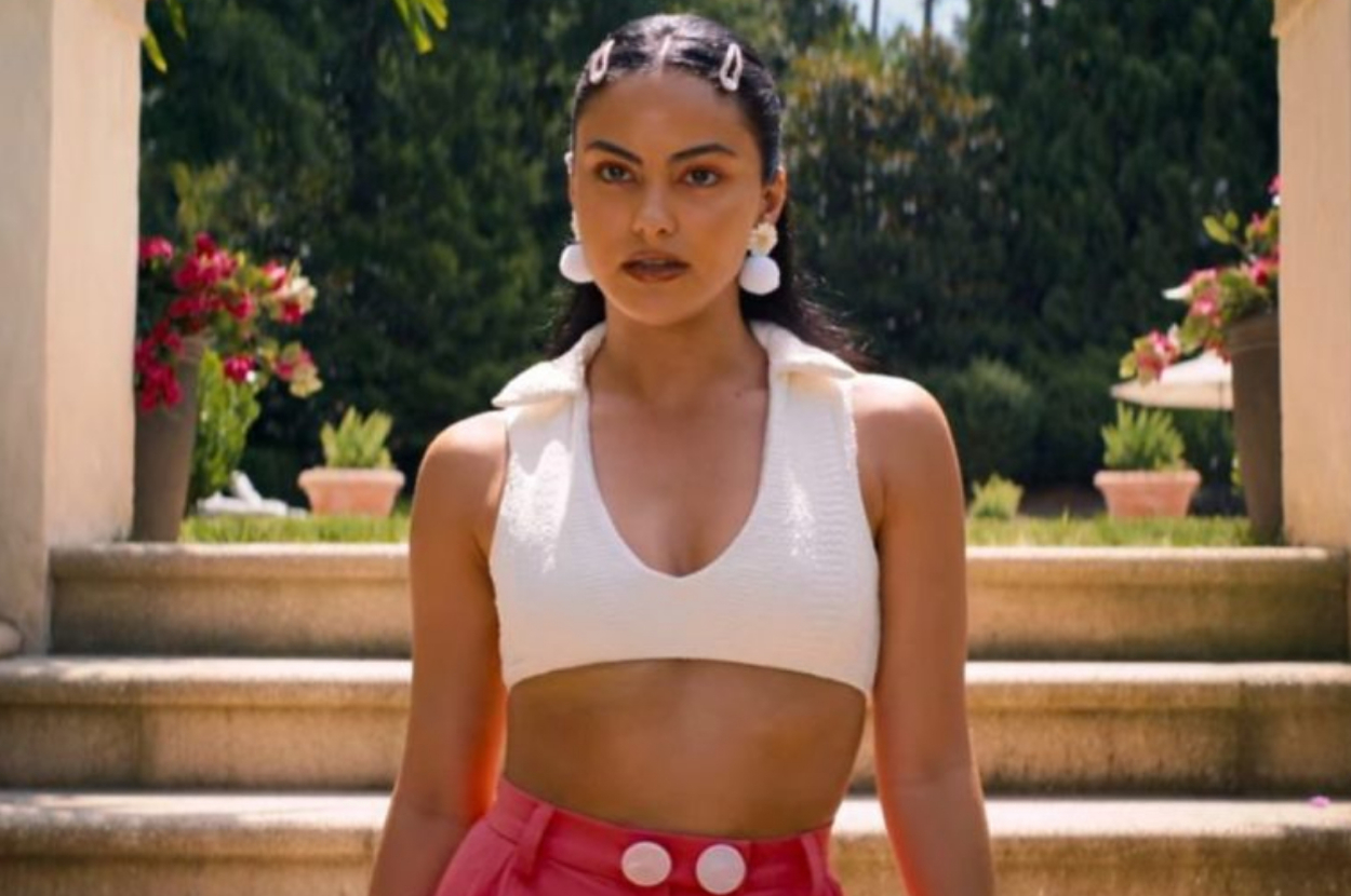 Camila Mendes poses in a cropped top and high-waisted shorts with button details