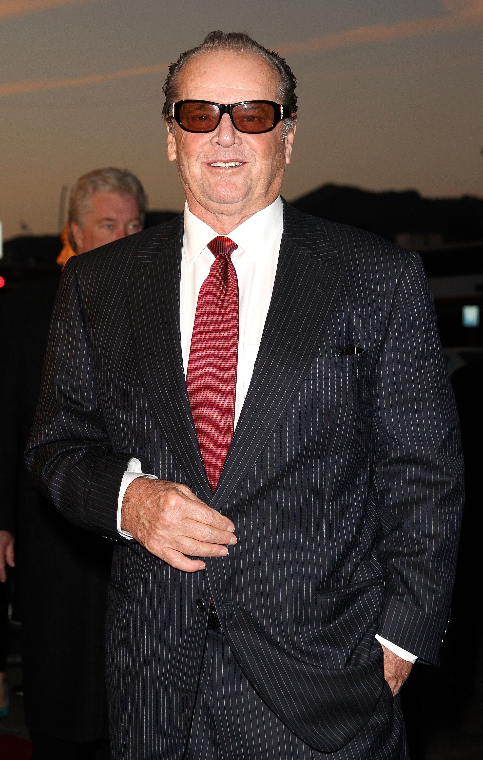 Man in pinstripe suit and red tie at event