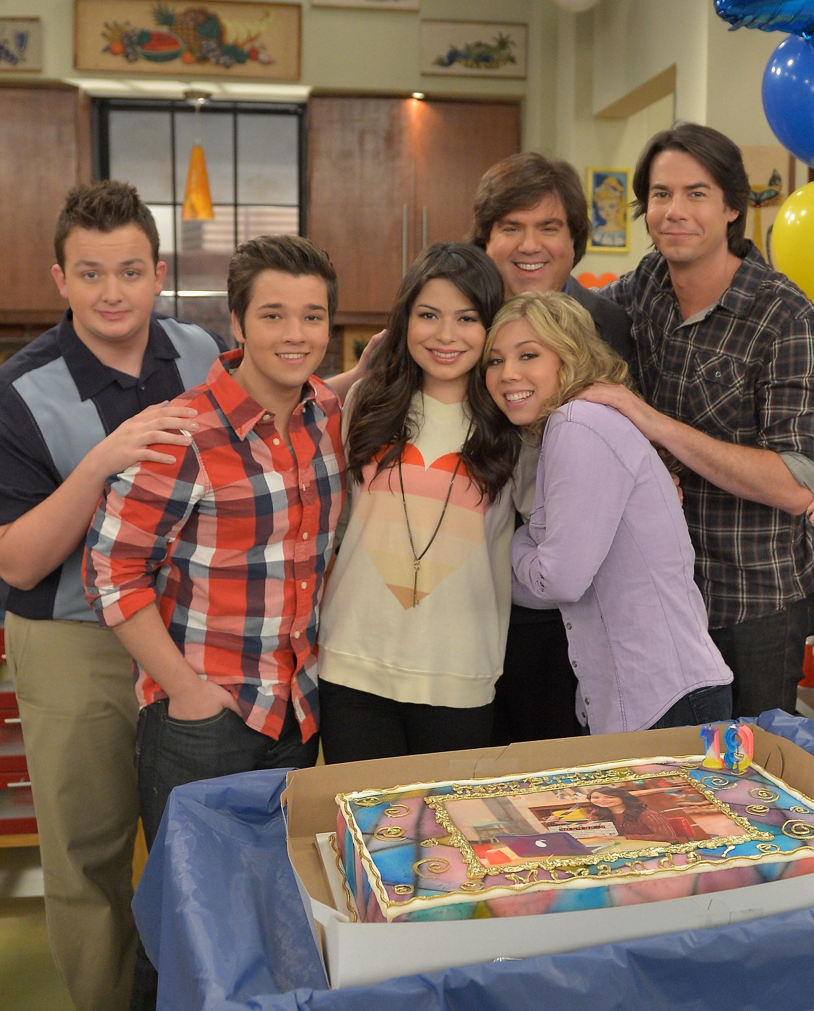 Cast of iCarly celebrating with a cake and balloons for the show&#x27;s 19th episode