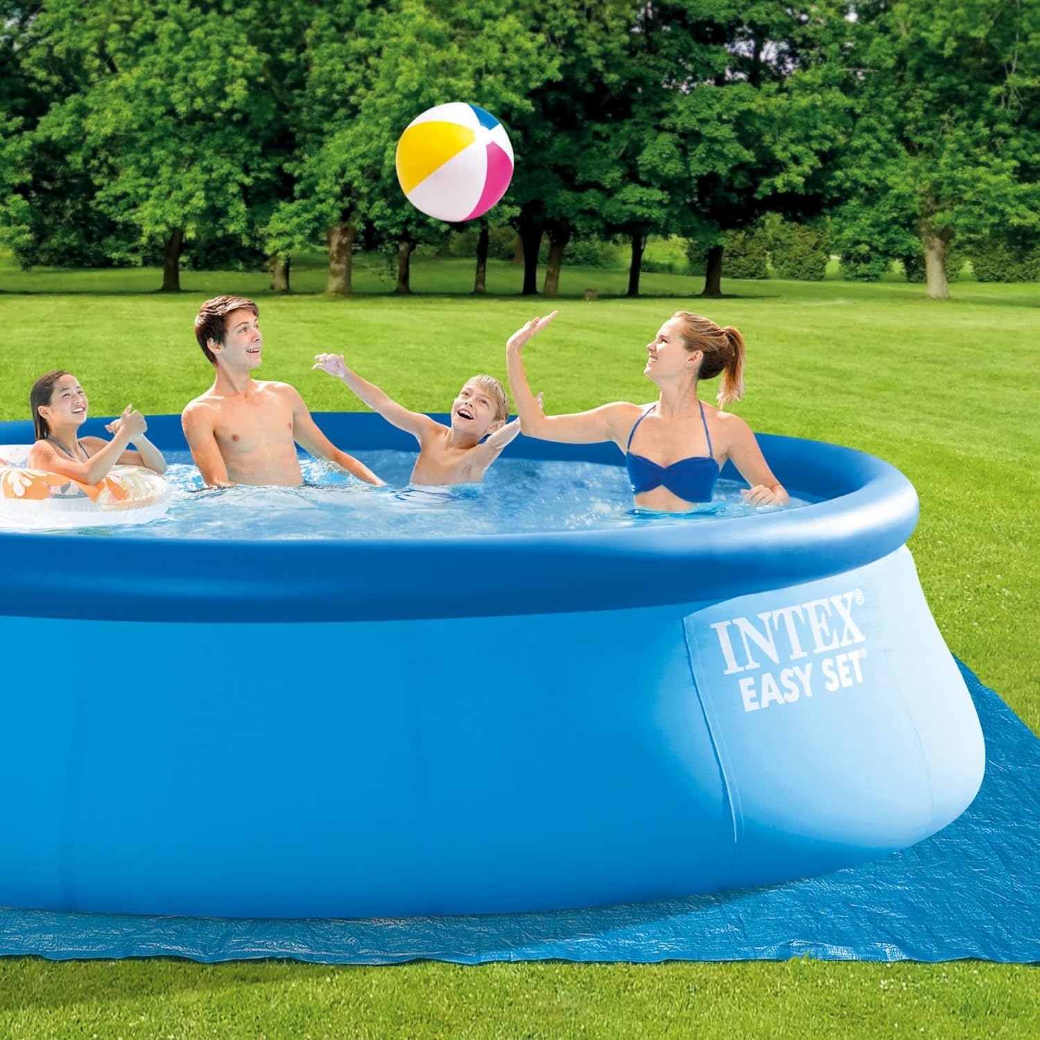 Family enjoys an INTEX Easy Set inflatable pool in a backyard, playing with a beach ball