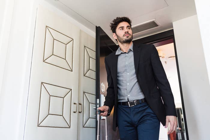 Man in a business suit exiting a room through an open door