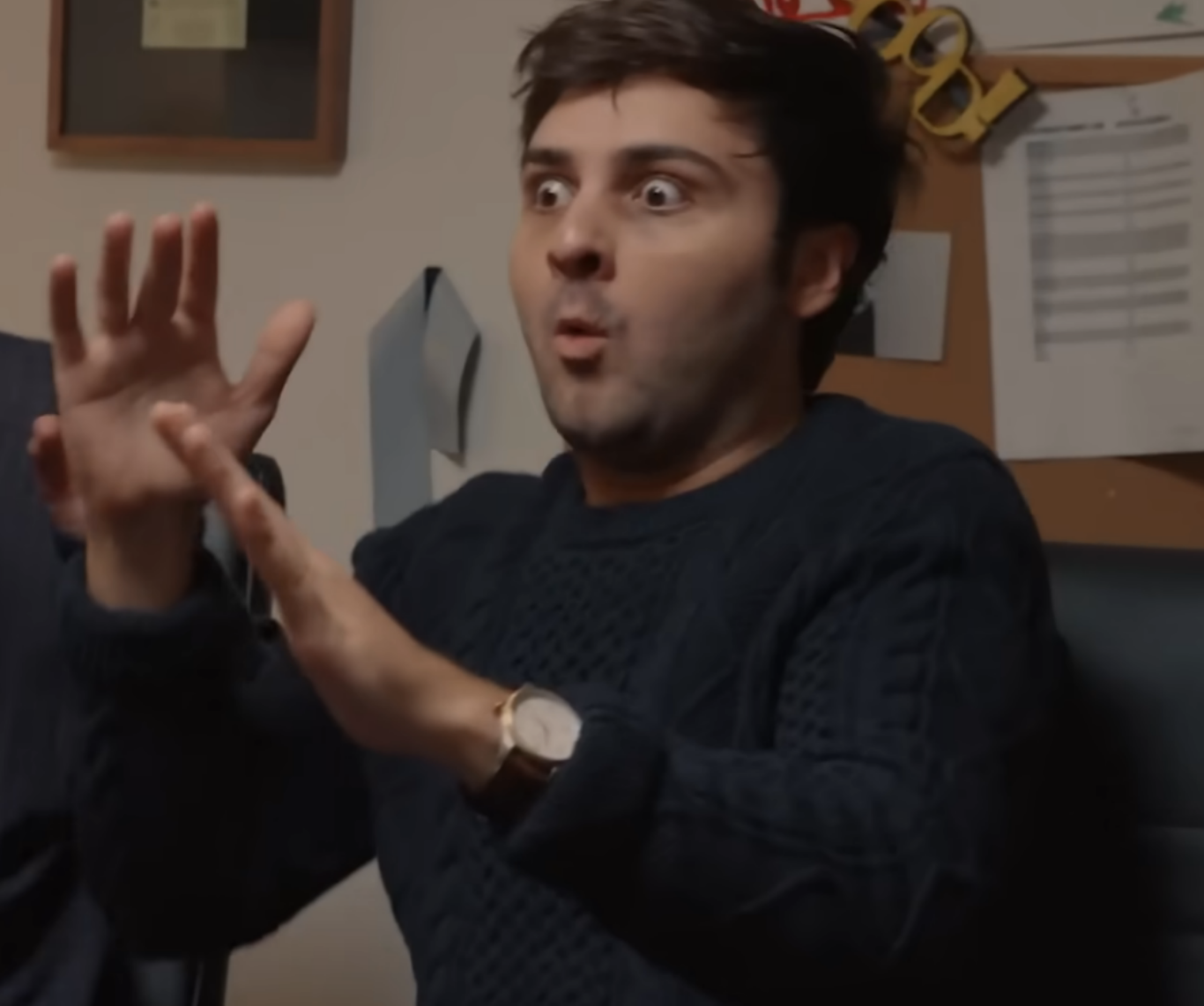 A man with his hands up looking shocked