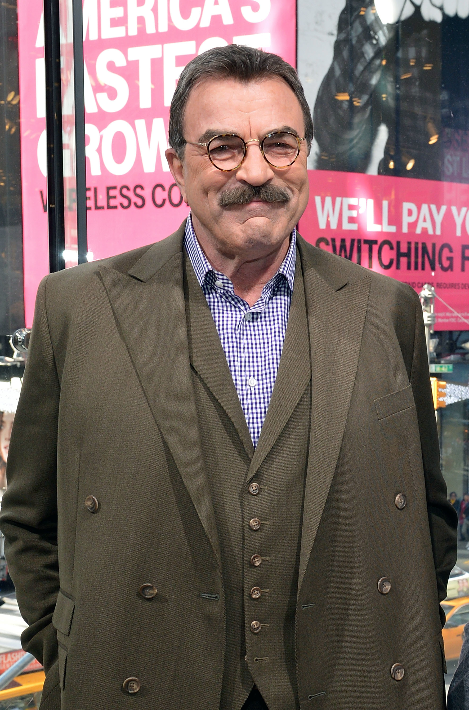 Tom Selleck in a double-breasted suit and checkered shirt at an event