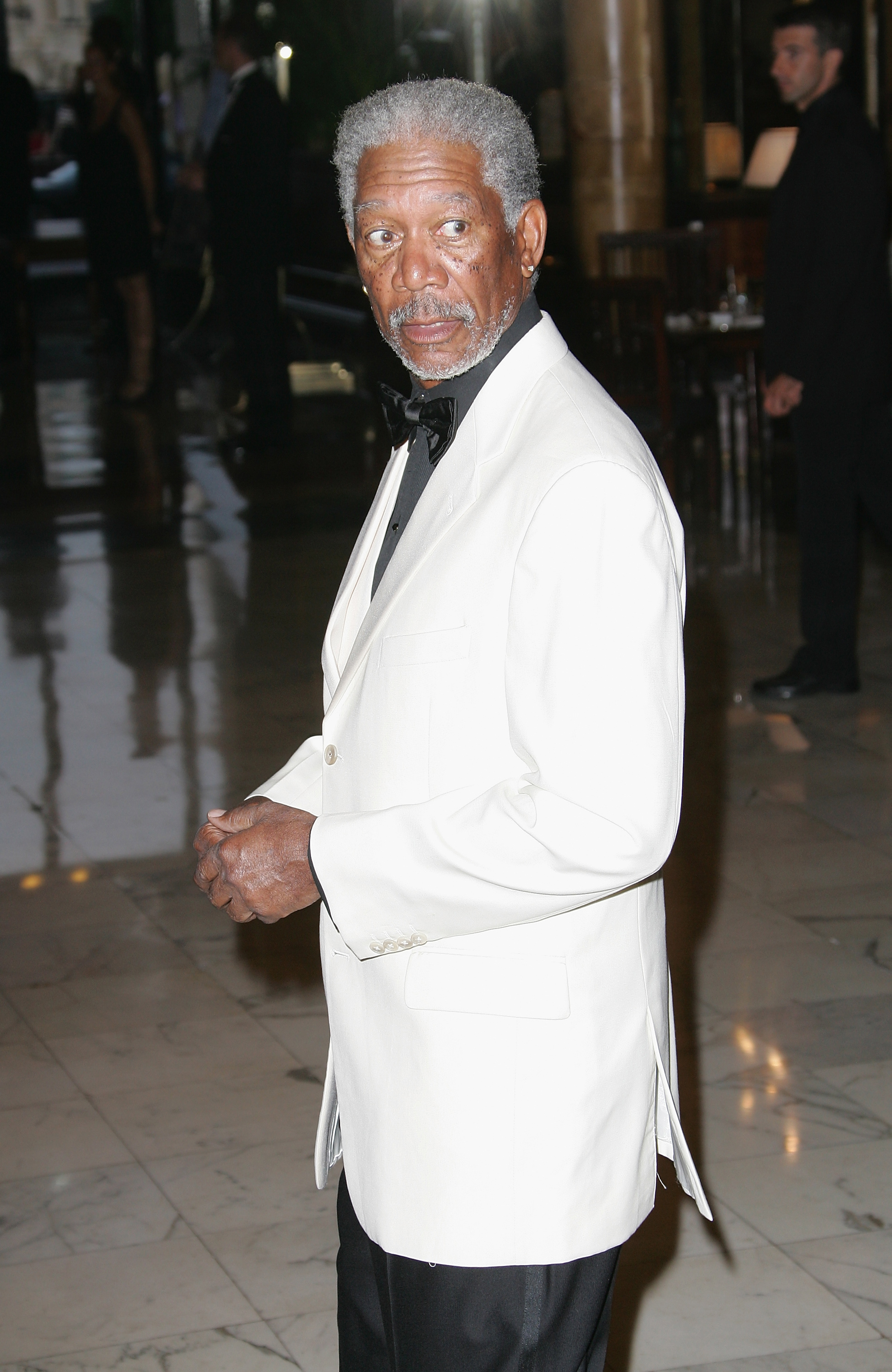 Morgan Freeman in a white suit jacket and black bow tie at an event
