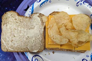 Open sandwich on a plate with one slice of bread with mayo, another with cheese and potato chips in between