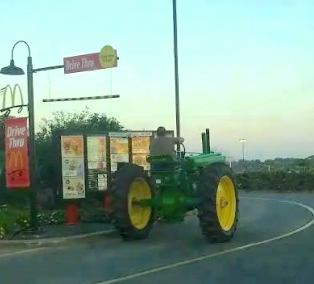 A tractor is queued at a McDonald&#x27;s Drive-Thru, showcasing an unconventional vehicle choice for fast food