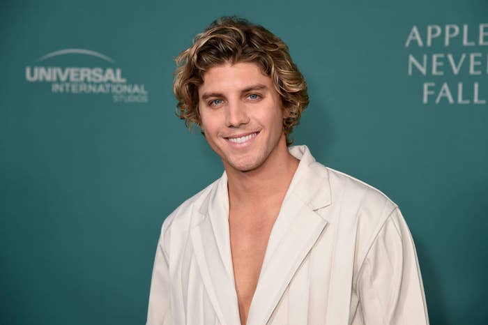 A coseup of Lukas Gage smiling on the red carpet