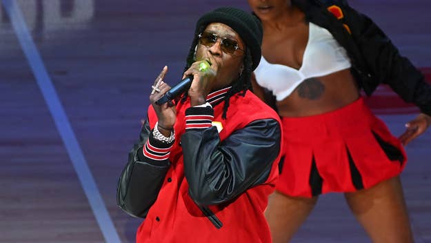 Lil Wayne performing on stage with backup dancers in sporty attire