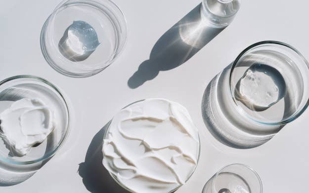 Assorted skincare products in clear containers with shadows on a surface