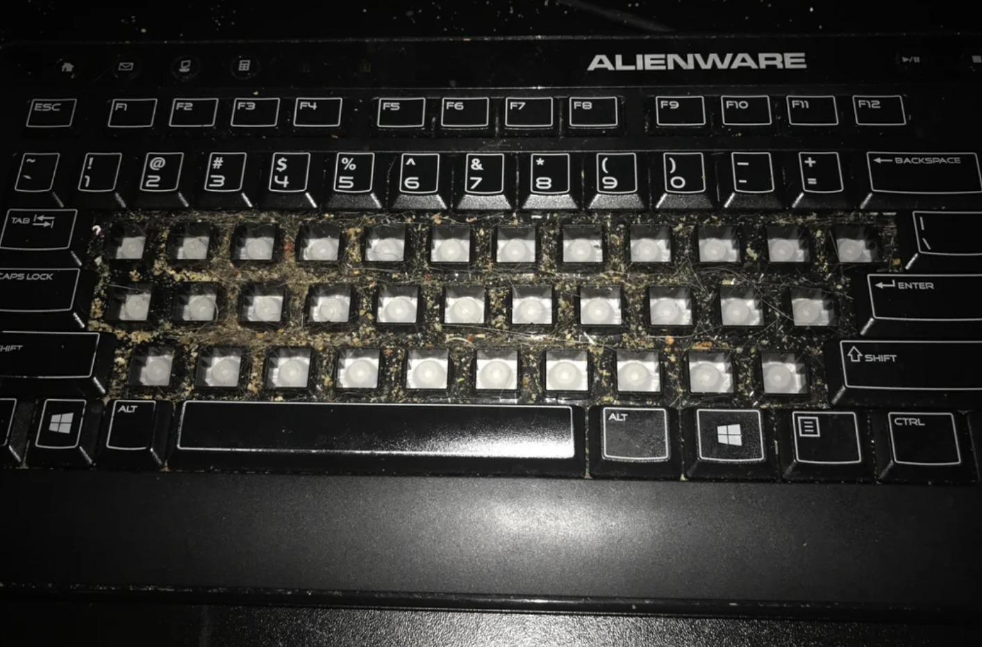 A very dirty computer keyboard with missing keys