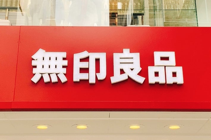 「赤い背景の上に白い文字で書かれた「無印良品」という店の看板」