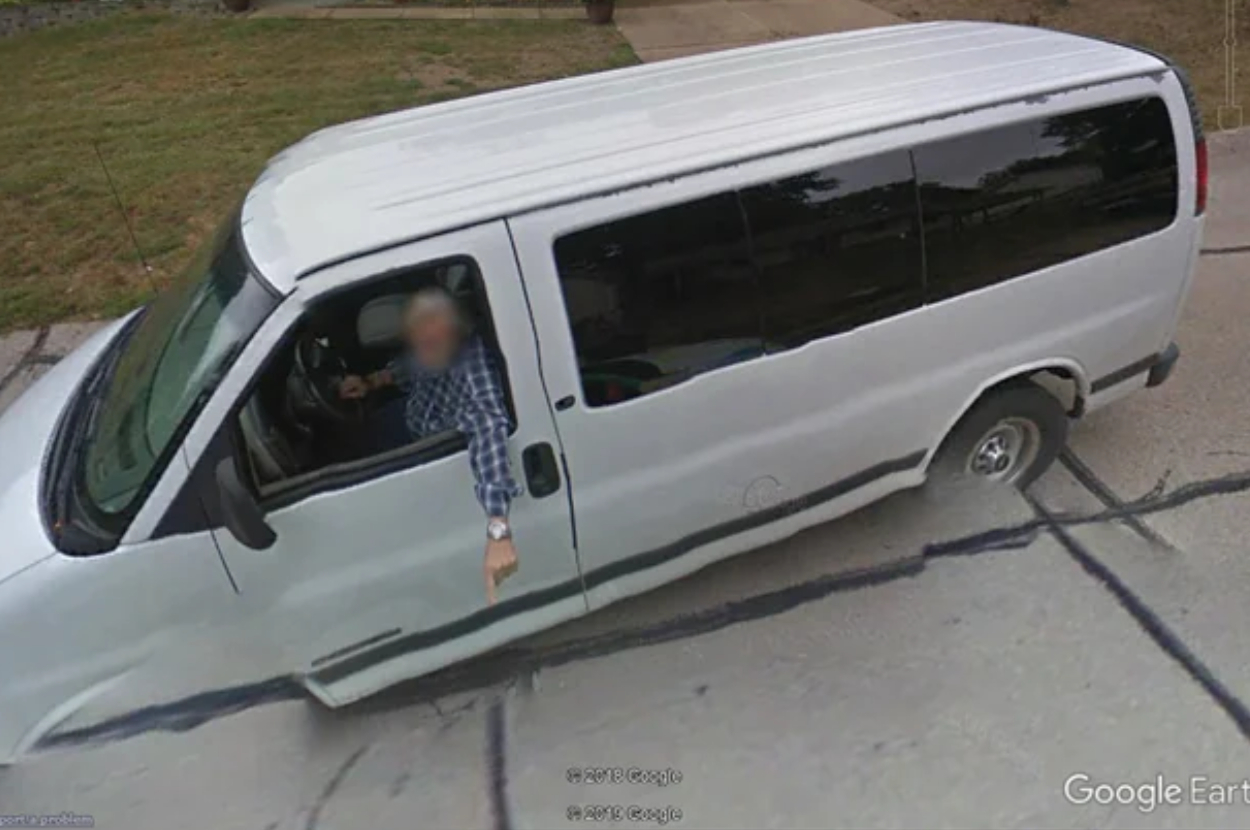 Aerial view of a white van with an open door and a person inside, taken from Google Earth