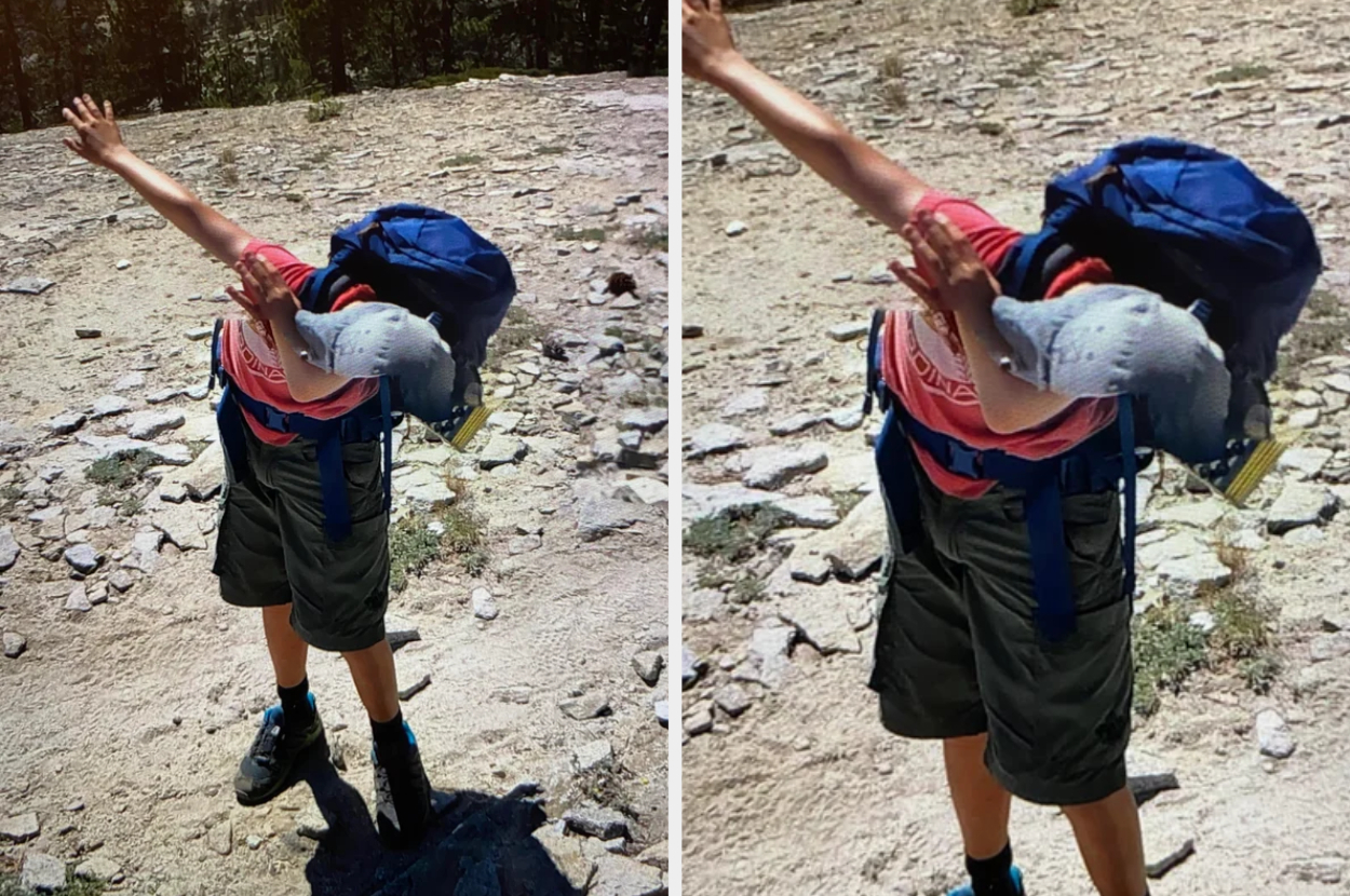 Child with an oversized backpack covers face with arm, outdoors on a rocky path