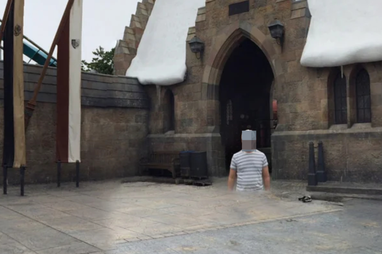 Person with striped shirt in front of a castle-like building entrance with snow details