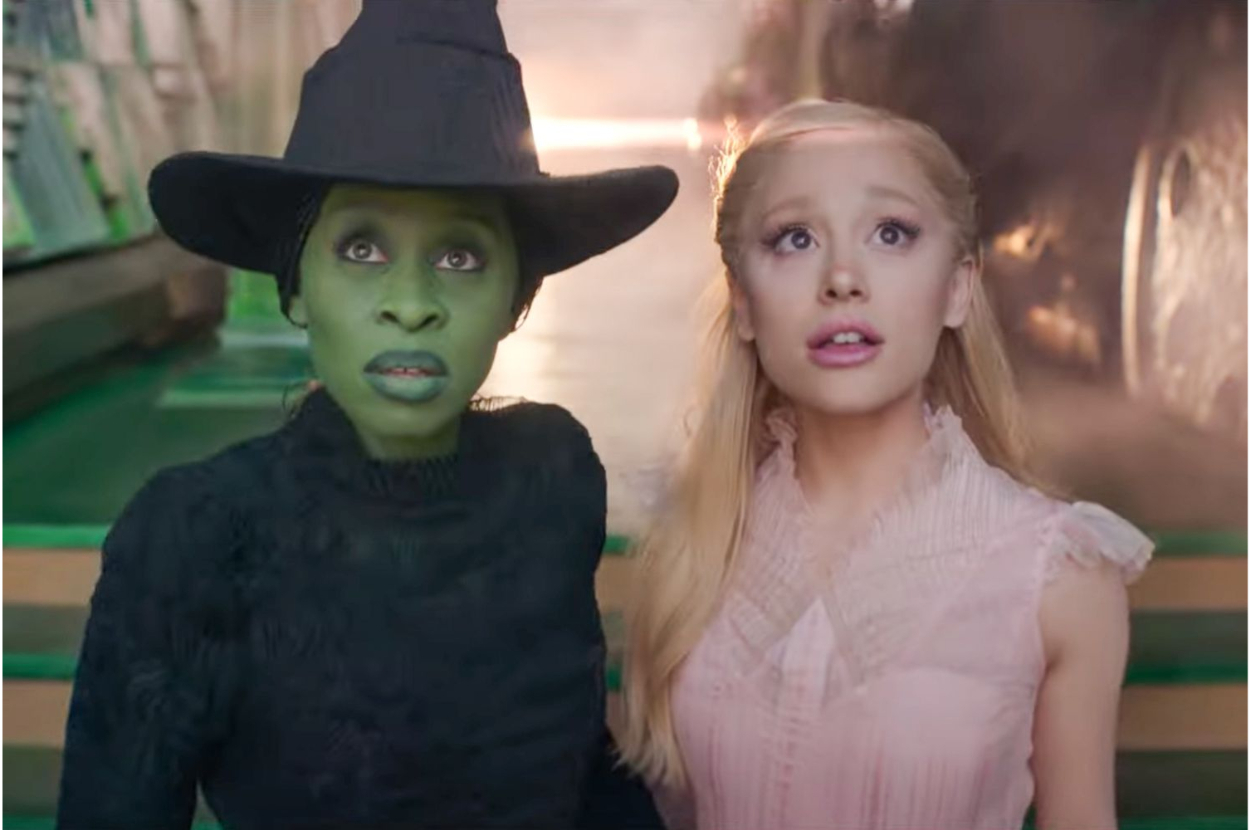 Elphaba in witch attire with hat and Glinda in pink dress from &#x27;Wicked&#x27;. They appear concerned
