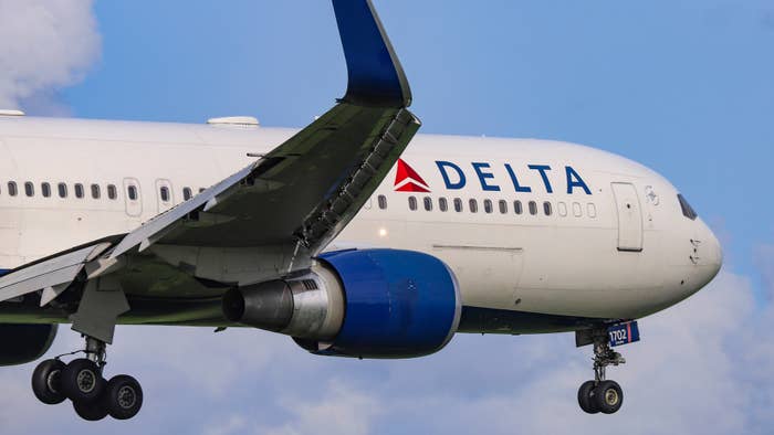 Close-up of a Delta Air Lines aircraft in flight, landing gear extended