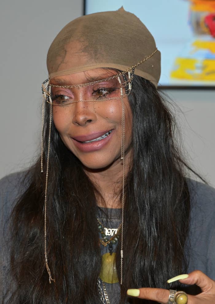 Close-up of Erykah Badu wearing a headwrap with hanging chains over her face