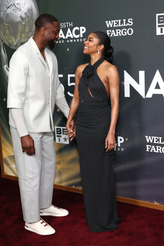 Dwayne and Gabrielle on the red carpet holding hands and looking at each other